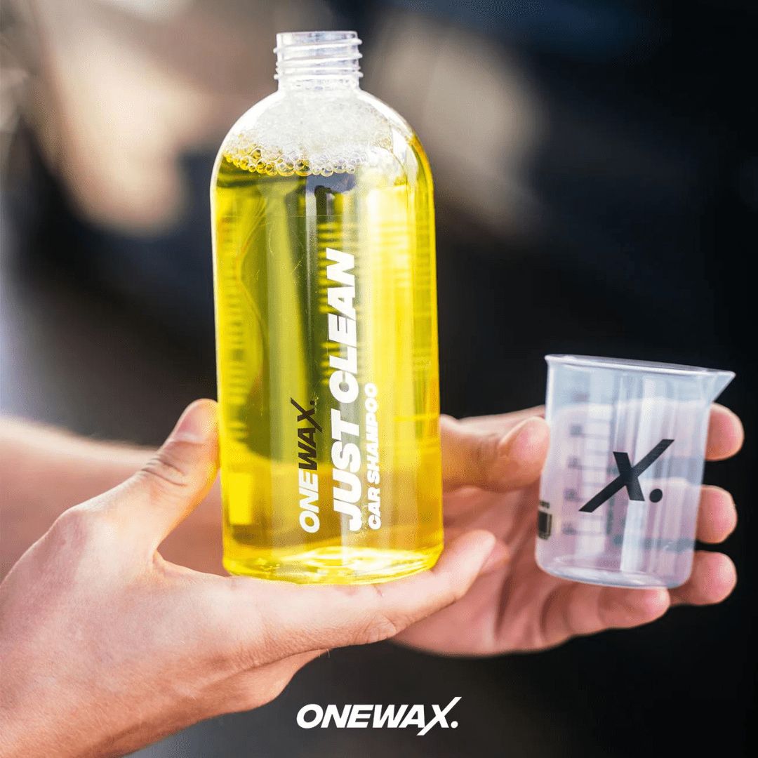 Die OneWax Just Clean Car Shampoo Flasche mit einem Messbecher