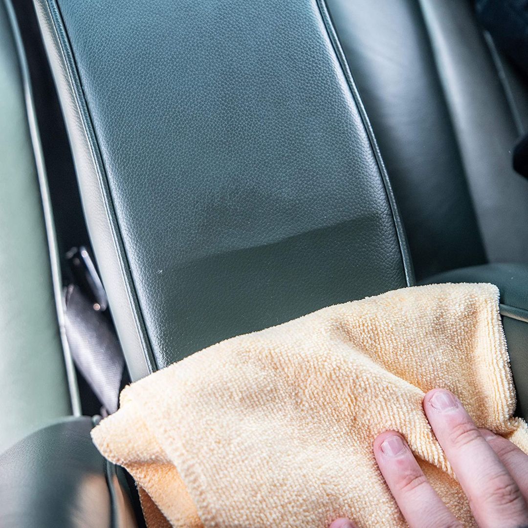 Auftragen der Meguiars Gold Class Leather Conditioner Lederpflege auf ein Ledersitz mit einem Mikrofasertuch