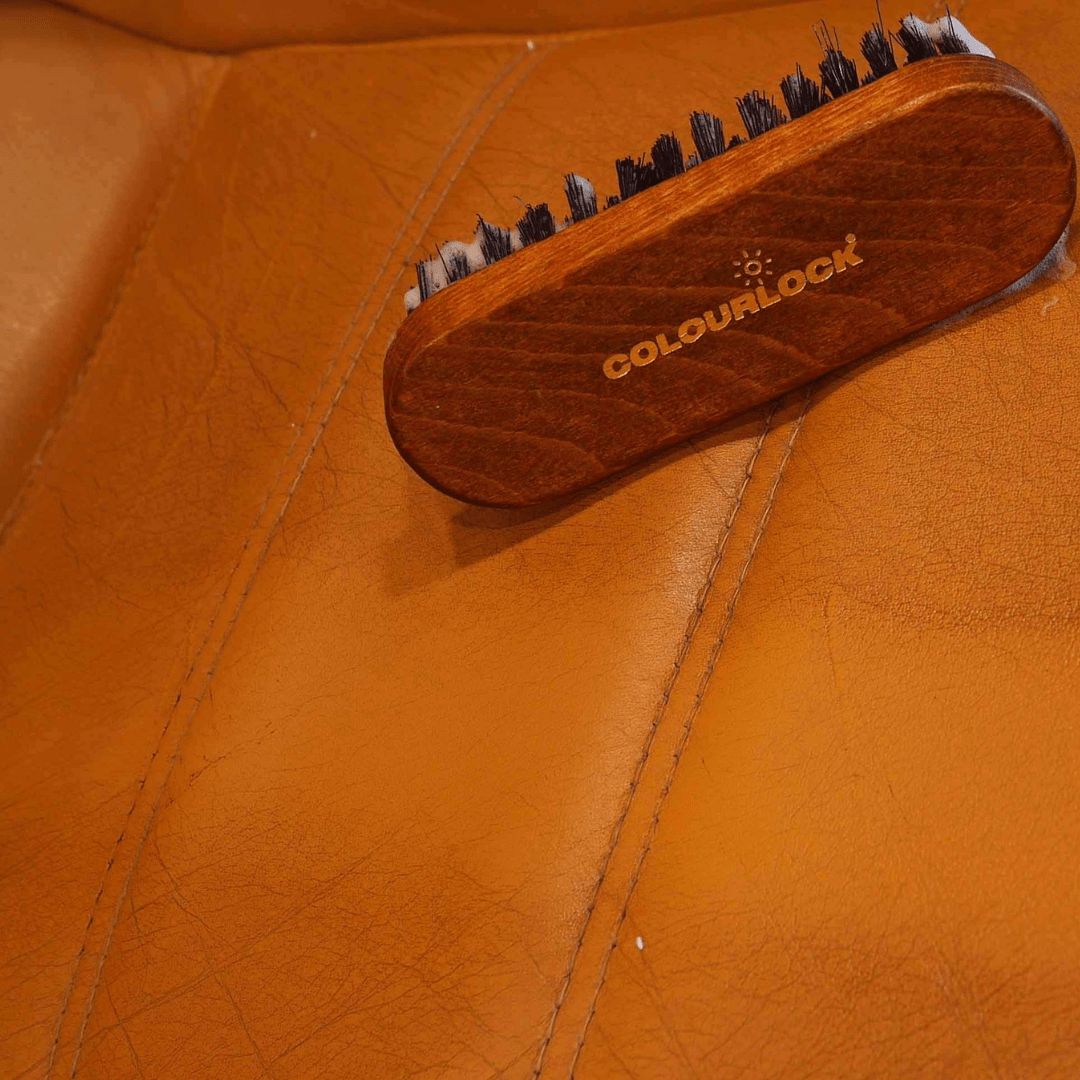 Die Colourlock Leder Reinigungsbürste auf einem braunen Ledersitz