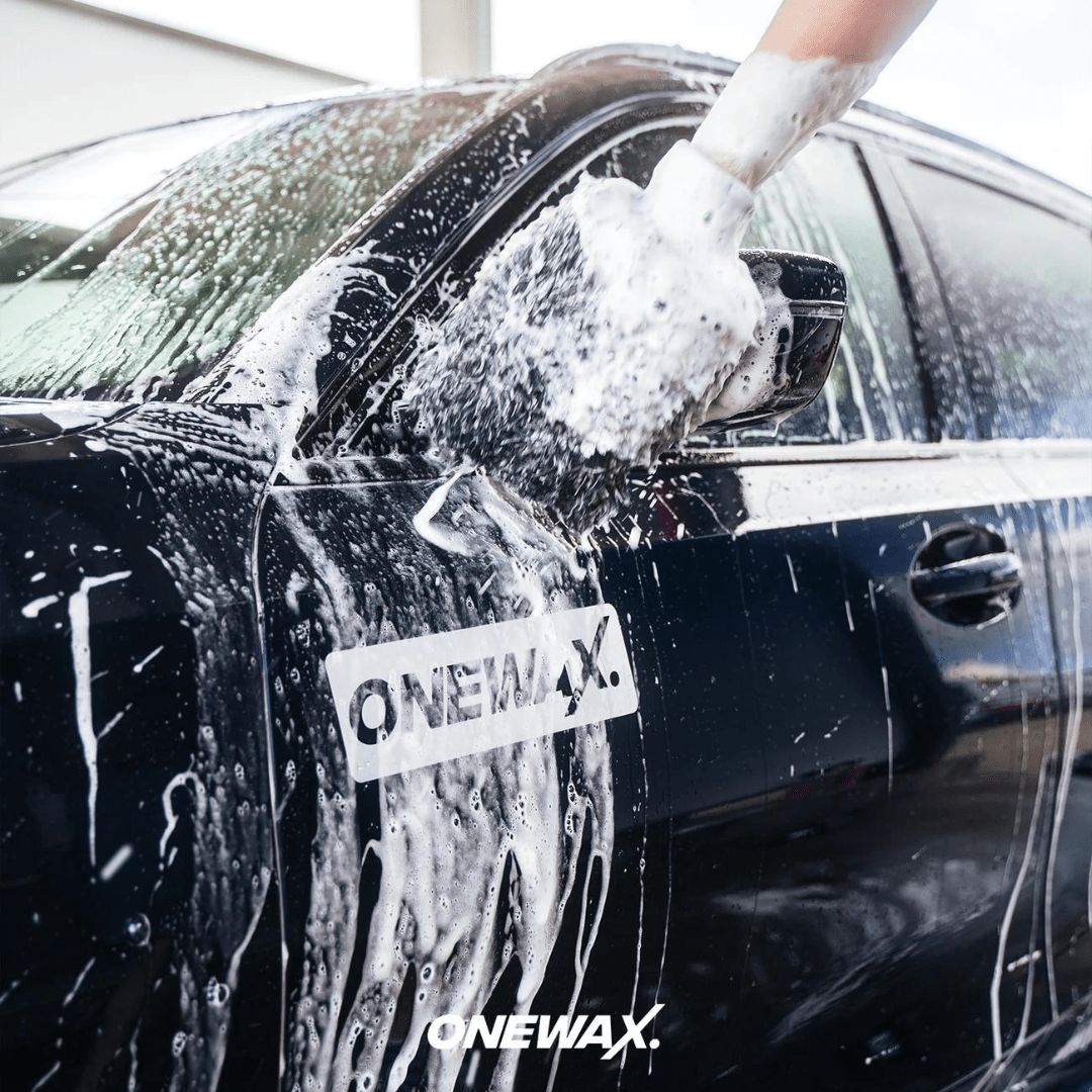 Ein Auto wird mittels einem Waschhandschuh mit OneWax Just Clean Car Shampoo gewaschen