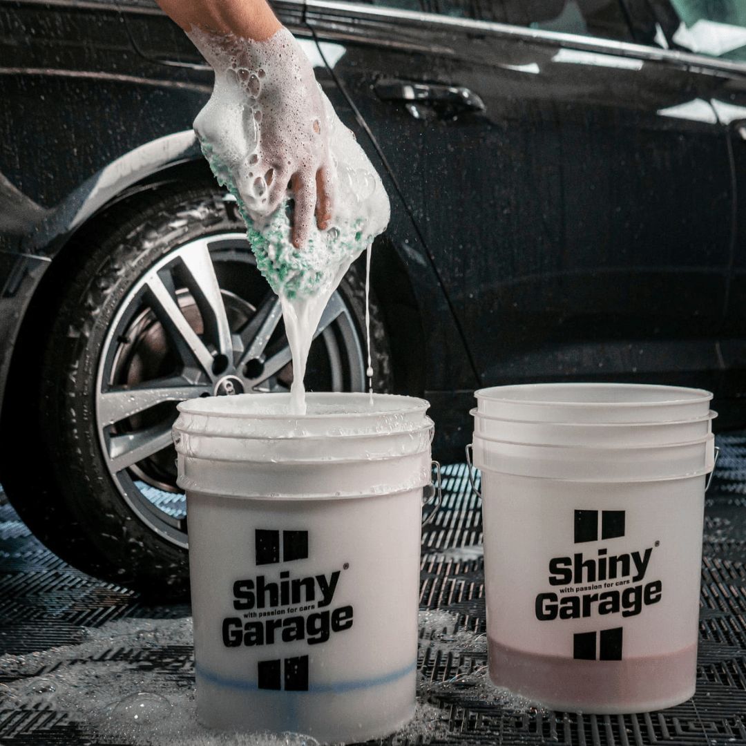 Zwei Wascheimer und aus einem wird ein Waschhandschuh gezogen