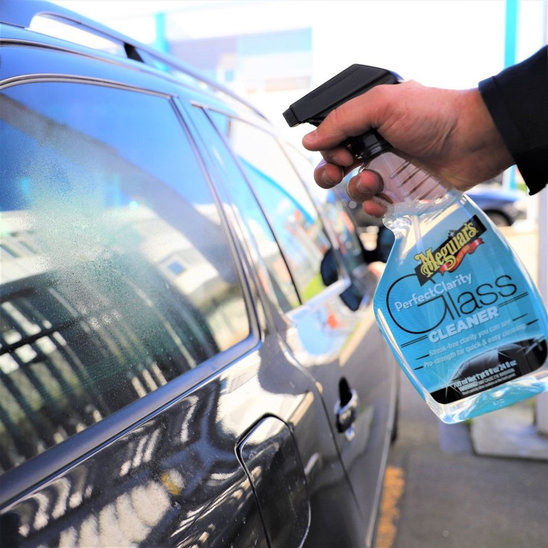 Aufsprühen des Meguiars Perfect Clarity Glass Cleaner Glasreiniger auf eine Autoscheibe
