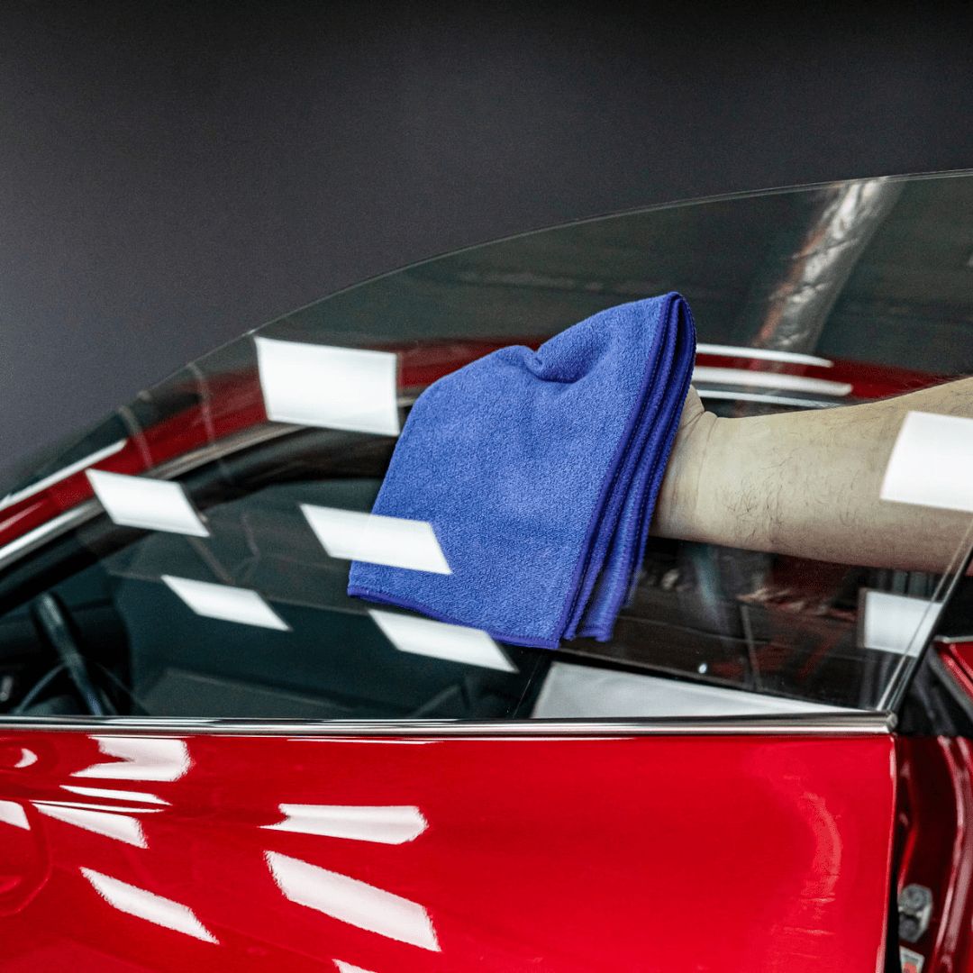 Die Autoscheibe wird mit einem Mikrofasertuch auspoliert