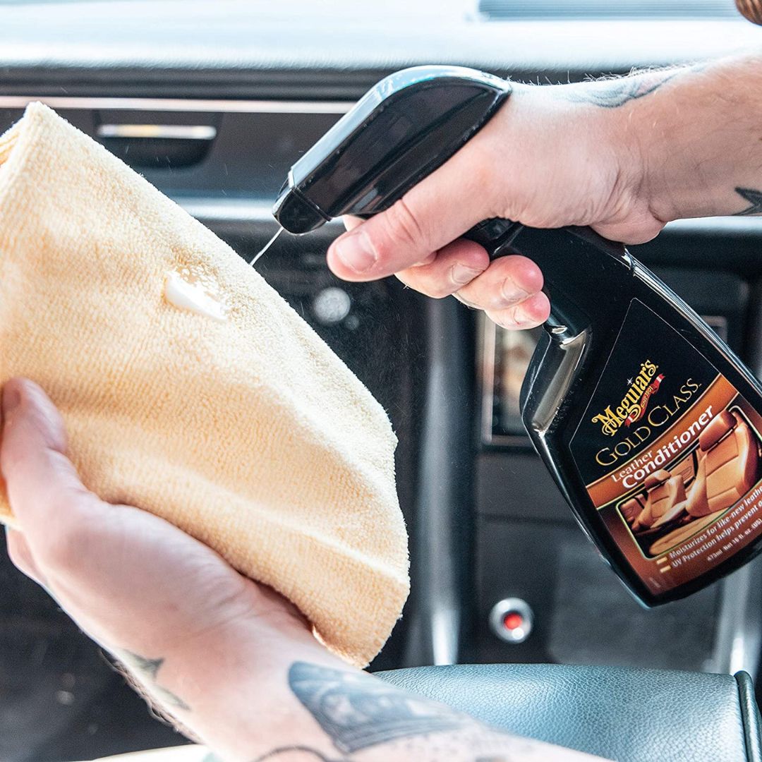 Aufsprühen der Meguiars Gold Class Leather Conditioner Lederpflege auf ein Mikrofasertuch