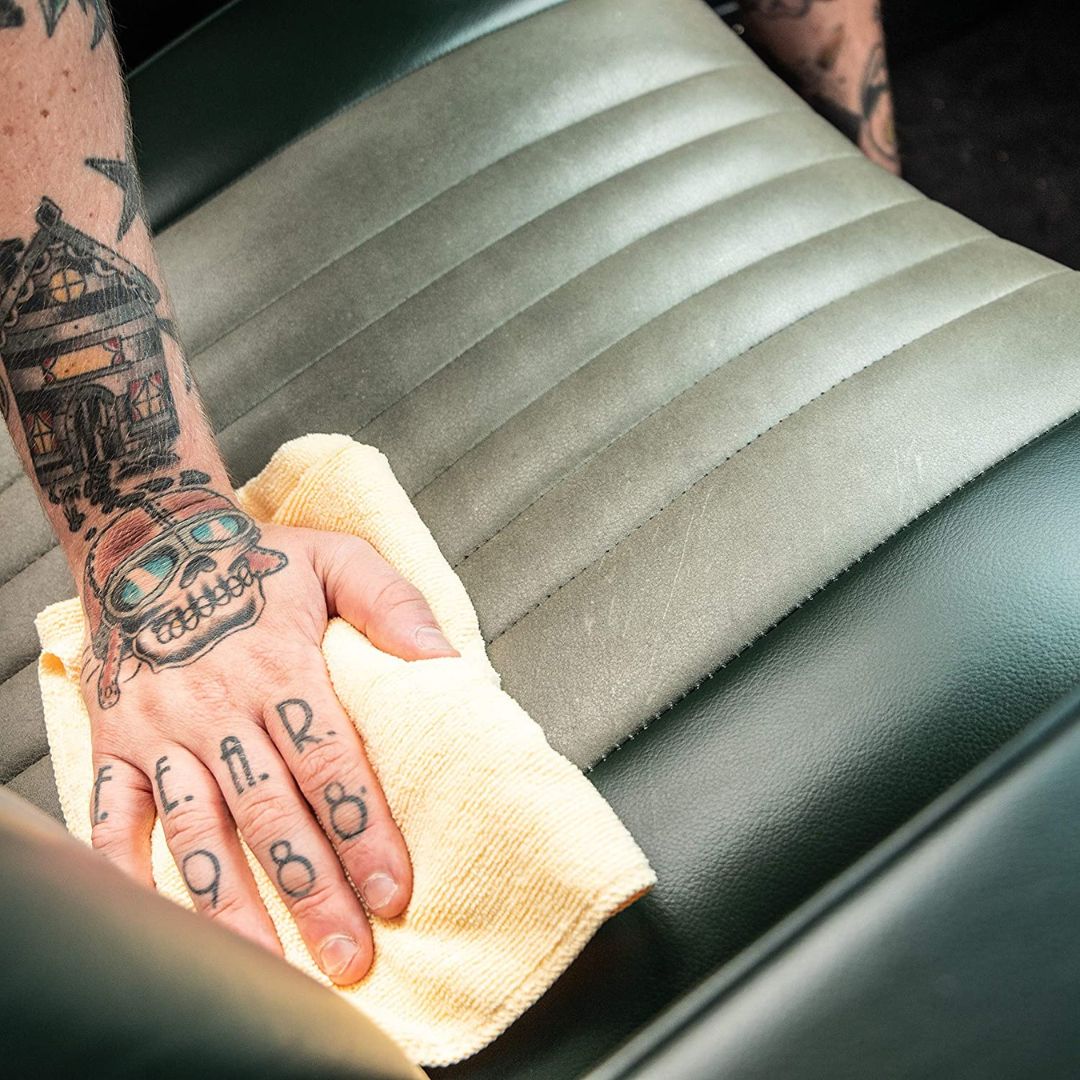 Auftragen der Meguiars Gold Class Leather Conditioner Lederpflege auf ein Ledersitz mit einem Mikrofasertuch