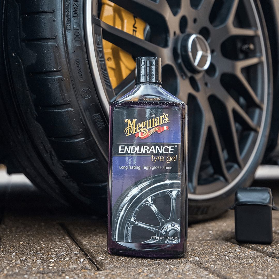 Die Flasche des Meguiars Endurance Tire Gel Reifenschwärzer vor einem Reifen