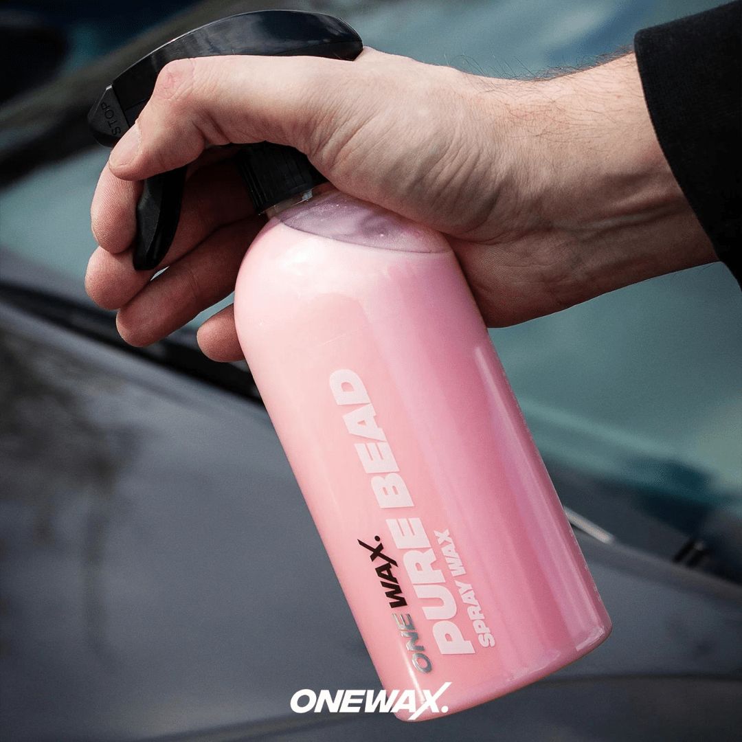 Die OneWax Pure Bead Spray Wax Sprühversiegelung Flasche vor einem Auto