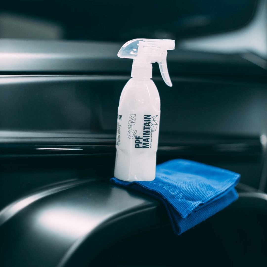 Die Sprühflasche der Gyeon Q²M PPF Maintain Folienpflege auf einem Mikrofasertuch