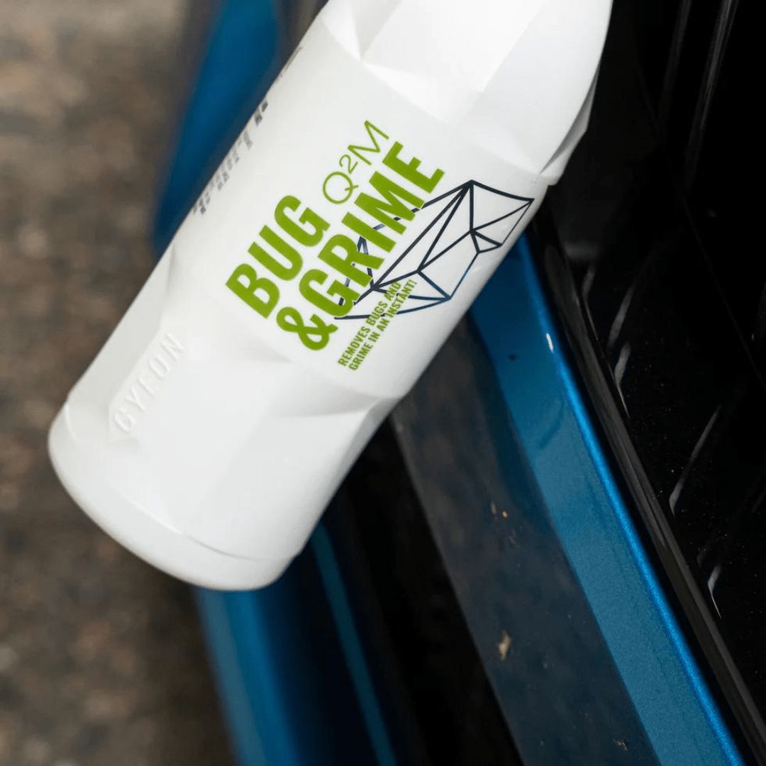 Der Gyeon Q²M Bug & Grime Insektenentferner vor einem Auto