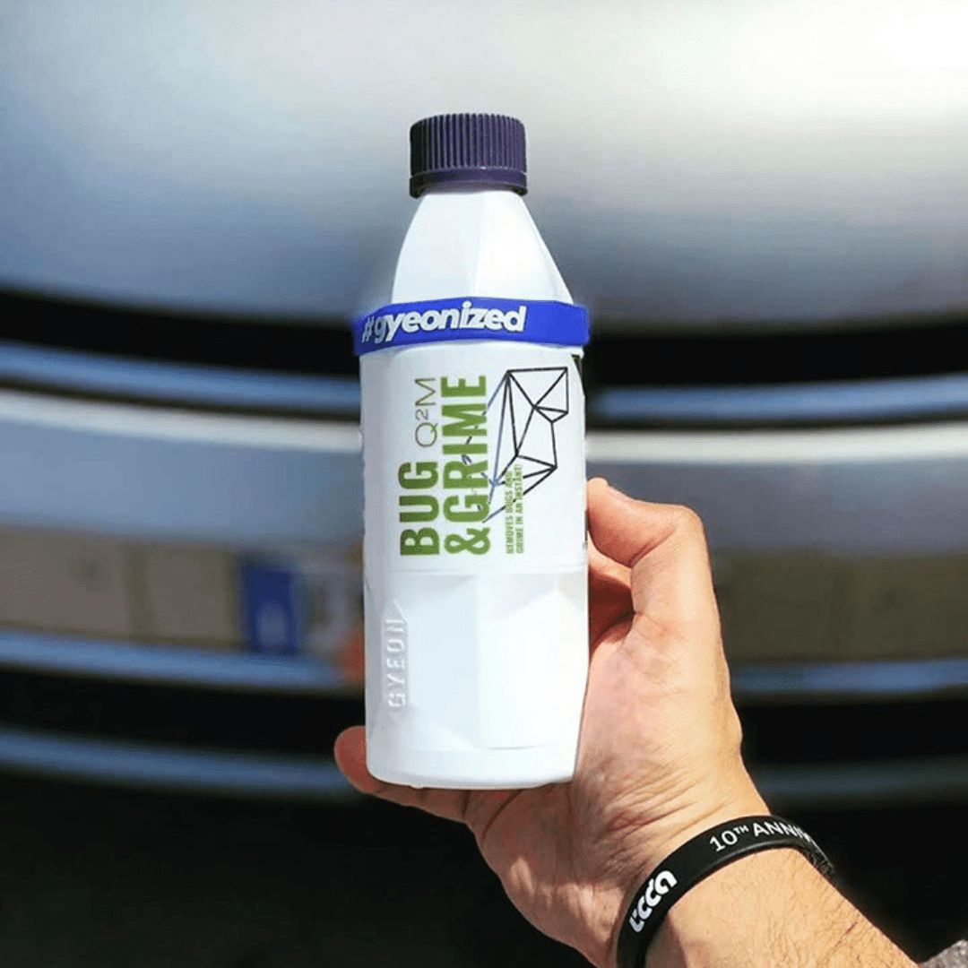 Der Gyeon Q²M Bug & Grime Insektenentferner vor einem Auto