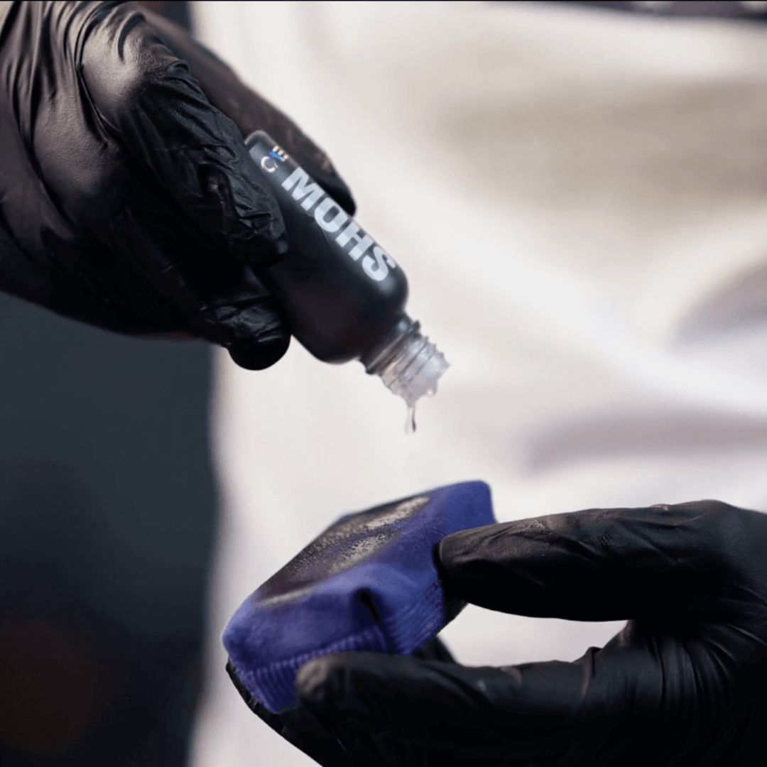 Tropfen der Gyeon Q² Mohs Keramikversiegelung auf einen Applikator