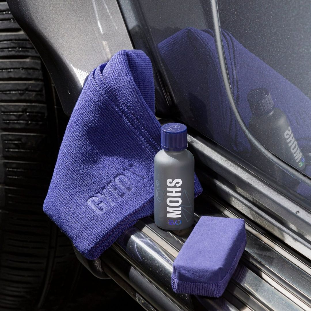 Die Gyeon Q² Mohs Keramikversiegelung mit Applikator und Poliertuch auf einem Auto