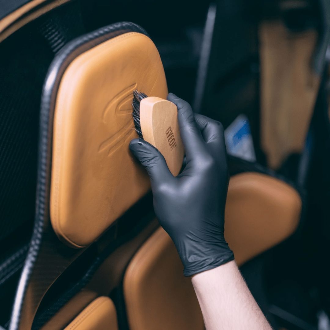 Die Gyeon Q²M Leather Brush Lederbürste angewendet auf einem Ledersitz