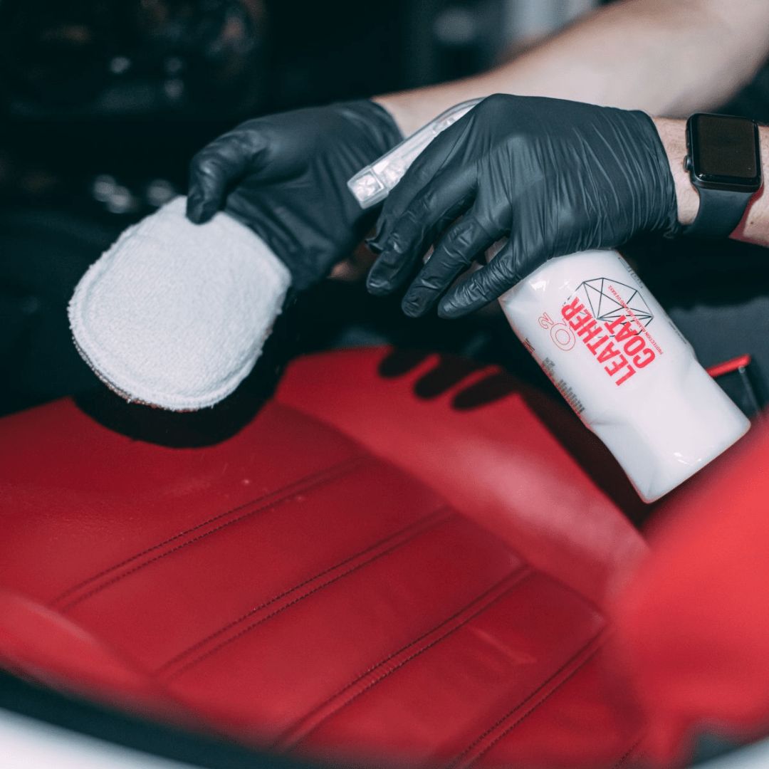 Aufsprühen der Gyeon Q² Leather Coat Lederversiegelung auf einen Applikator