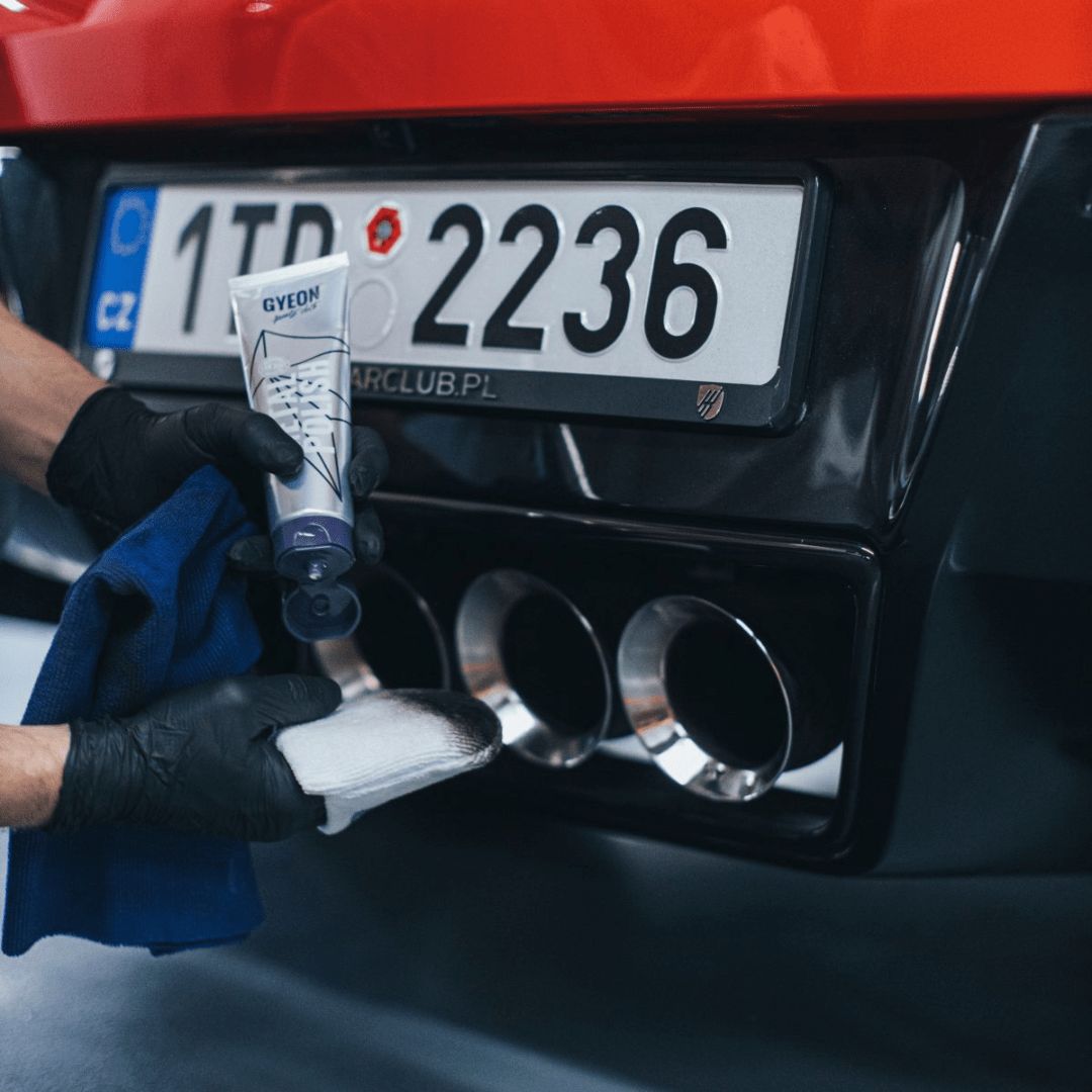 Auftragen der Gyeon Q²M MetalPolish Politur auf ein Mikrofaserapplikator vor einem Auspuff