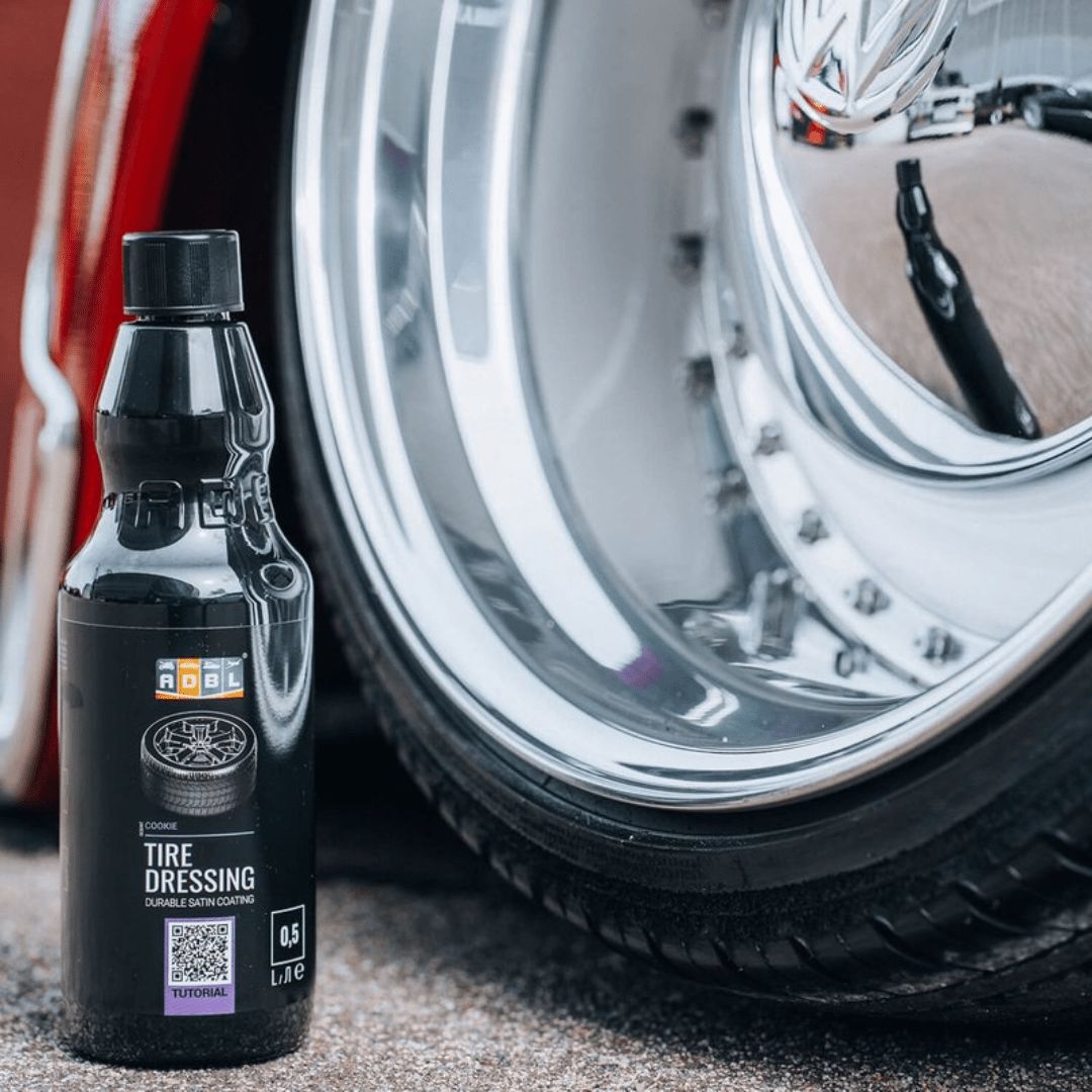 Die Flasche ADBL Tire Dressing Reifenpflege neben einem Reifen