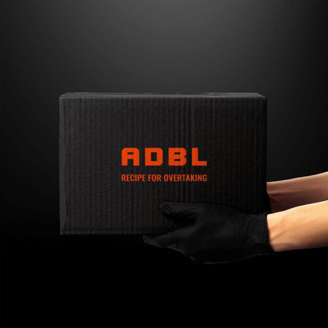 Eine schwarzes Paket mit ADBL Aufschrift wird ins Bild gehalten