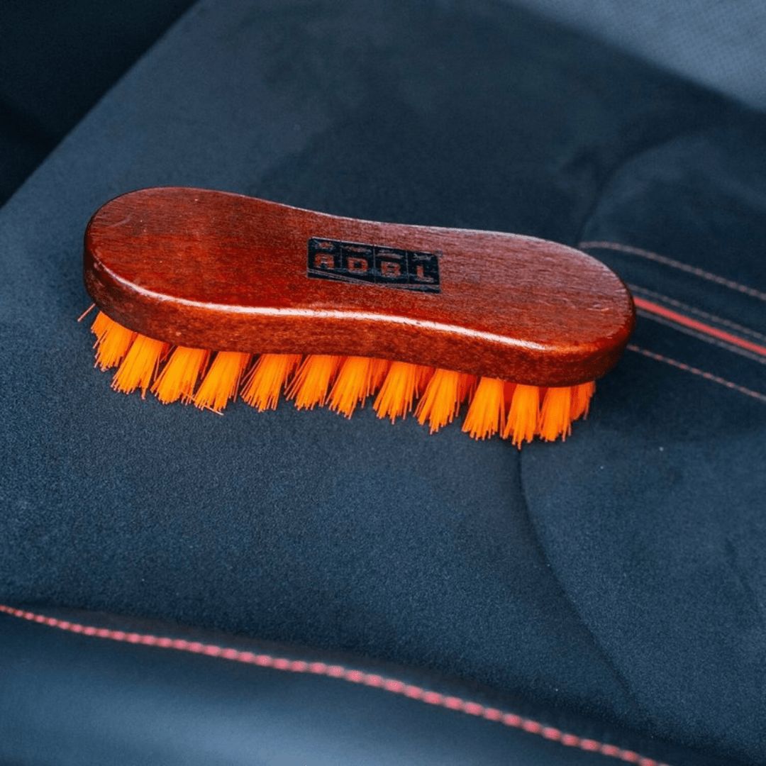 Die Die ADBL Textile Brush Textilbürste auf einem Autositz