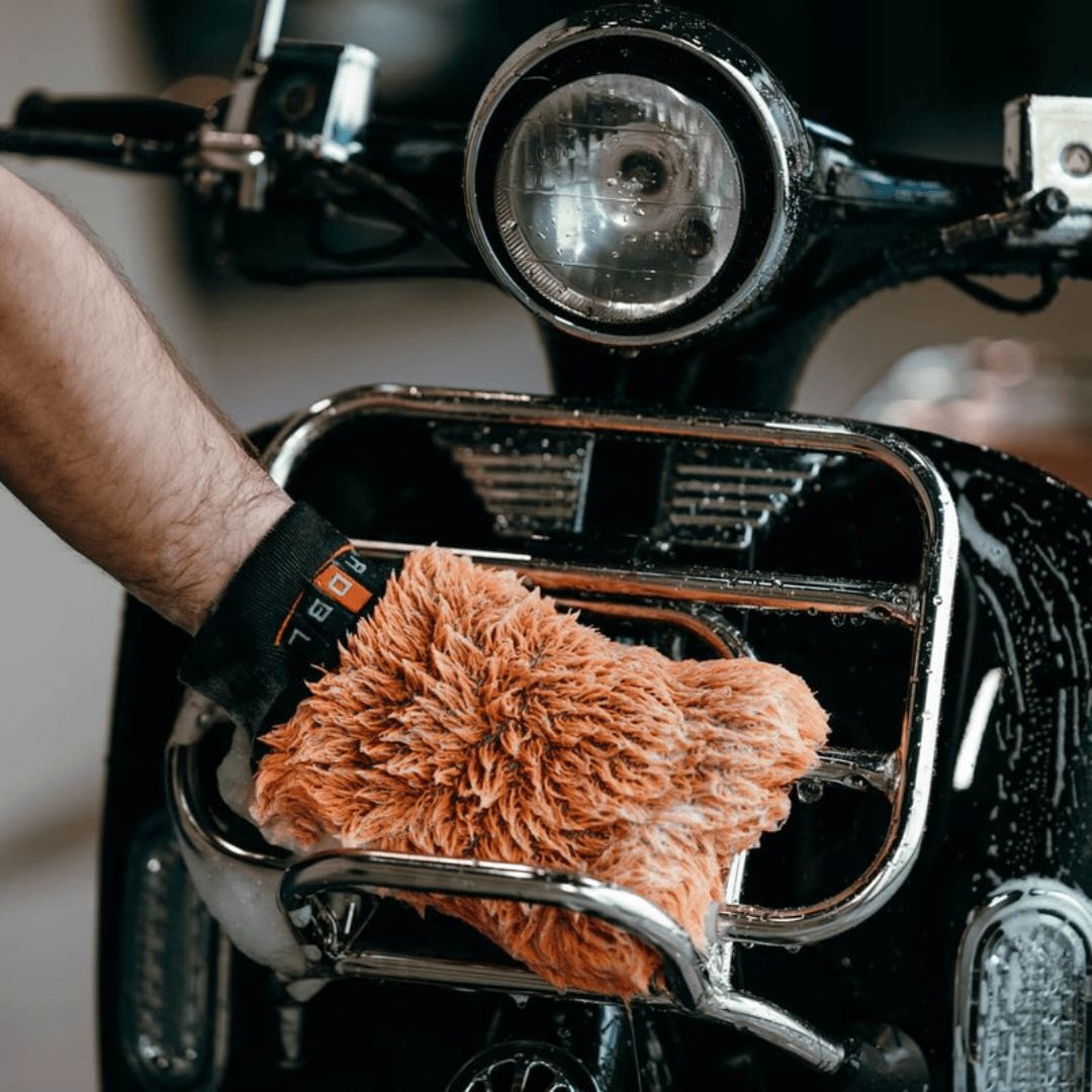 Der ADBL Caremitt Waschhandschuh gleitet über ein Motorrad
